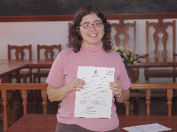 Belinda Rodríguez Arrocha muestra la acreditación de la concesión del premio.